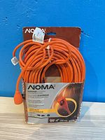 Front view of NOMA 30 m outdoor locking extension cord in packaging