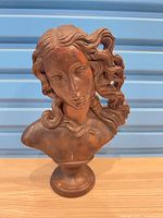 Front view of bronze-tone female bust sculpture on pedestal