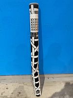 Rolled black and white indoor/outdoor rug in plastic wrap