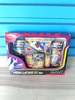 Front view of sealed Mega Latias EX Box showing contents through window