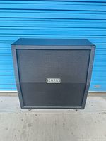 Front view of Mills Acoustics Afterburner 412A cabinet showing grille and badge