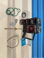 overview of jewelry box with assorted jewelry items laid beside