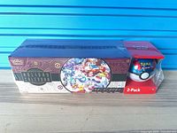 Sealed Holiday Calendar box and sealed Poké Ball Tin 2-Pack side by side