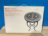 factory box front showing image of round ceramic tile top side table