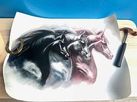 Curling lithograph print of three horses with signature visible