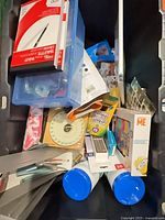 Bin containing assorted stationery and toys