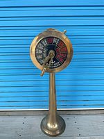 Full view of brass engine room telegraph on pedestal
