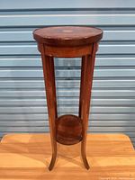 Full view of wooden plant stand showing overall design with top and lower shelf