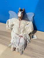 Front view of horse doll in lace dress with wings and hang tag