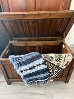 blanket box open with two throws draped