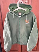 Front view of green hooded Tigger windbreaker on hanger