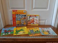 All six books laid out with ruler for scale