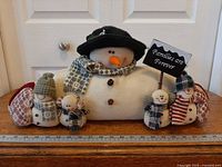 Front view of snowman draft stopper showing large snowman, four mini snowpeople, sign and full length