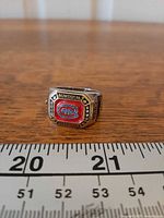Front view of ring showing Montreal Canadiens logo and accent stones beside ruler