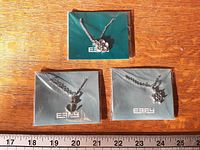 All three packaged EFFY necklaces on wood surface with ruler for scale