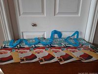 Five identical Christmas gift bags laid flat showing front design and handles