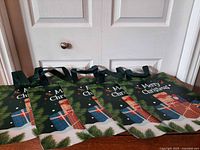 Five green Merry Christmas reusable gift bags displayed