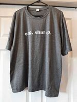 Front view of gray heathered t-shirt on hanger showing overall condition and style