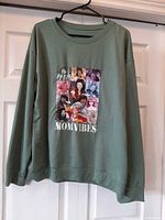 Front view of green sweatshirt on hanger showing graphic and overall condition