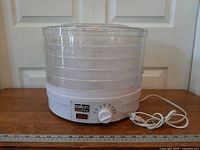 Front view of Salton VitaPro food dehydrator with trays, lid, dial and cord visible