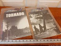 Both newspaper supplements in sleeves beside ruler