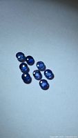 Eight round blue cabochon sapphires on white background