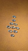 Group of ten oval light blue faceted gemstones on brown surface