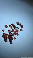 cluster of square orange-red garnets on blue background