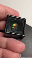 Opal in black plastic display box showing bright colour play
