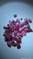 Group of small rough ruby crystals on white background