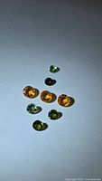 Eight mixed-colour round sapphires on white background