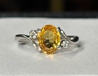Front view of white gold ring showing oval yellow citrine and accent stones
