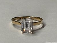 Top view of ring showing emerald-cut cubic zirconia and gold band