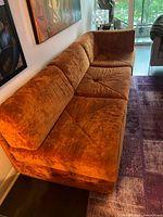 Full view of one side of sectional showing crushed velvet upholstery and tufted cushions