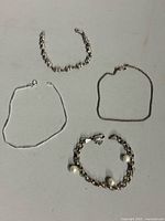 Four sterling silver bracelets laid out