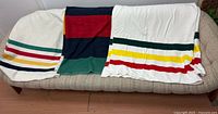 Three Hudson’s Bay Company blankets laid out on sofa