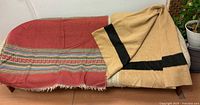 Both blankets displayed on bench, showing overall colours and patterns