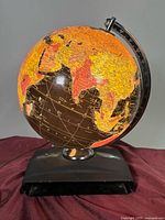 Front view of illuminated globe showing Asia and base