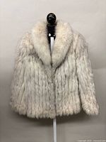 Front view of fox fur jacket on stand