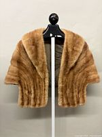 Front view of honey-brown mink stole on hanger