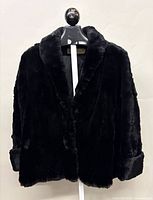 Full front view of black sheared beaver jacket on hanger