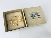 Closed pair of gold and pearl hoop earrings in Morse Jewellers box
