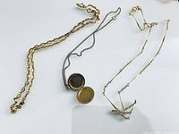 All three necklaces laid out; locket visible