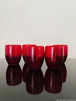 Front view of five ruby red glass tumblers