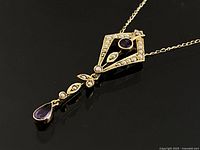Front view of gold pendant necklace showing amethyst center, seed pearls, pear amethyst drop and chain