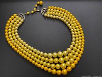 Full view of four-strand yellow bead necklace