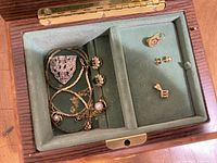 Open jewelry box showing velvet compartments and assorted jewelry pieces