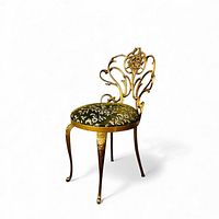 Full view of gilt bronze chair with floral backrest and velvet seat