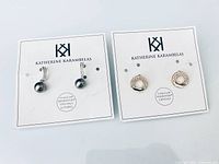 Both pairs of earrings on branded cards