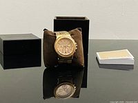 Watch on cushion with box and booklet